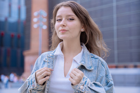 Happy Caucasian young woman looking at camera and smiling in urban settingの写真素材