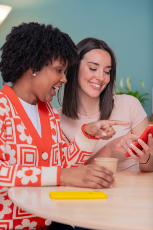 African American and Caucasian friends smiling while looking at smartphone together