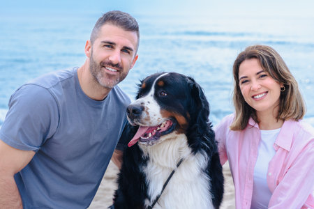 Caucasian couple portrait with dog on beach vacation smiling at the cameraの写真素材