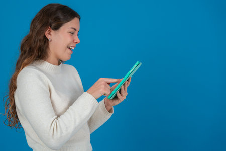 Smiling Woman Touching Digital Tablet Screen with Copy Space on Blue Background