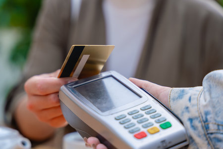 Close-up of contactless credit card payment at cafe with point of sale terminalの写真素材
