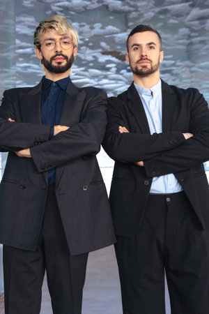 Two confident businessmen standing with arms crossed and serious at camera