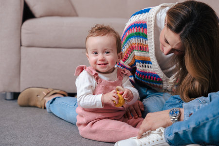 Smiling parents sitting on floor with baby girl holding toy during family moment