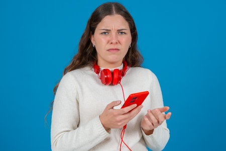Frustrated woman holding red smartphone with confused expression on her face