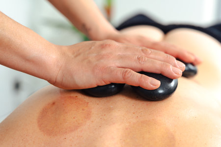 Hot stone massage therapy on back for relaxation and muscle pain reliefの写真素材