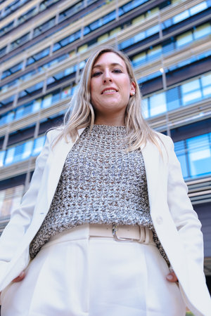 Businesswoman with serious expression looking at camera in front of officeの写真素材