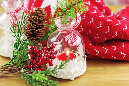 Candle and berries on pine brunch with christmas fabricの写真素材