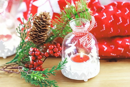 Candle and berries on pine brunch with christmas fabricの写真素材