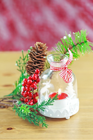 Candle and berries on pine brunchの写真素材
