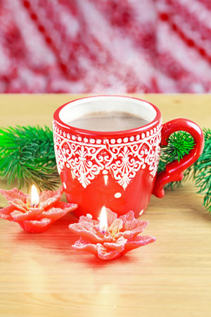 Cup of hot cocao with red poinsettia candle and pineの写真素材