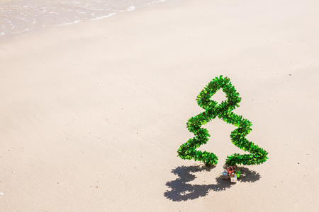 Christmas tree of tinsel on seacoast with white sand on Phuket island, Thailand - concept of holidays and vacation in tropicsの写真素材