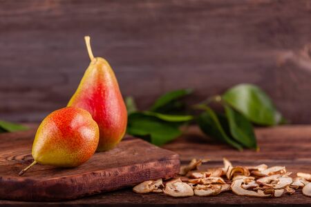 Fresh red pears with homemade dried fruits on wooden background, healthy foodの写真素材