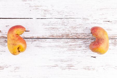 Ugly organic fruits ripe pears on white wooden table background with copy spaceの写真素材