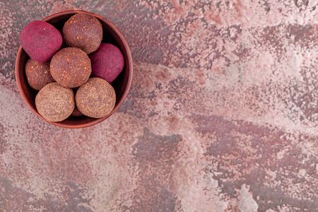 Homemade Colorful Raw Vegan Cocoa Energy Balls in Wood Bowl on Marble Backgroundの写真素材