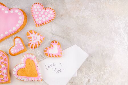 Paper Napkin with Love Message Text and Handmade Glazed Cookies on White Marble Background. Concept of Happy Valentines Dayの写真素材