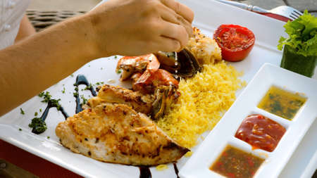 Chef hand squeeze lemon juice to seafood platter with charcoal grilled shrimpsの写真素材