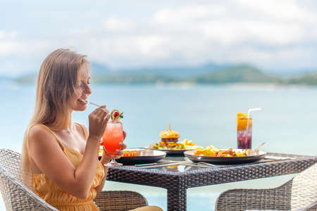 Lunch table and luxury travel woman on vacation, view of sea, enjoy vacationの写真素材