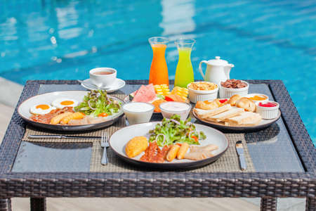 American breakfast near swimming pool, exotic food at luxury hotel resortの写真素材