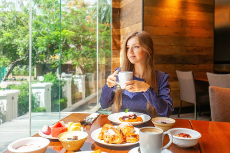 Attractive woman on breakfast in hotel restaurantの写真素材