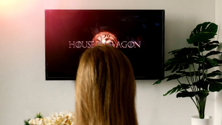 Woman relaxing at home and watching on TV House of the Dragon