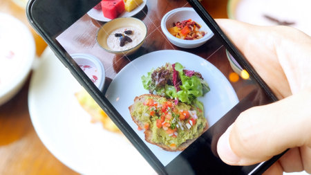 Man hands taking photos of healthy vegan dinner food by smartphoneの写真素材