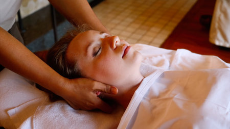 Young unrecognizable woman gets professional neck and head massageの写真素材