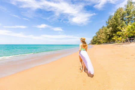 Happy traveller woman in swimwear enjoys her tropical beach vacationの写真素材