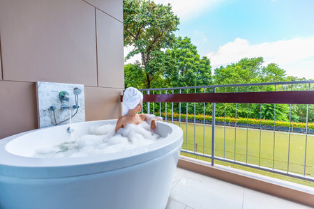 Female person indulges in a spa bathing experience with foam on terrace
