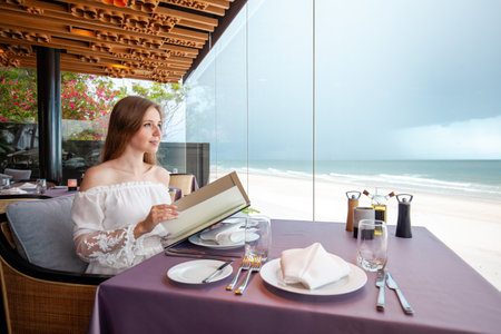 Elegant young adult at beachfront restaurantの写真素材
