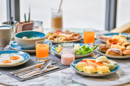 Varied breakfast spread on table with fresh juice and coffee. Healthy food and lifestyle.の写真素材