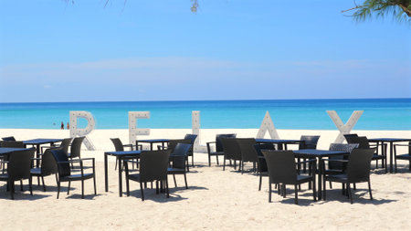 Tropical beach restaurant with RELAX sign set up on white sandの写真素材
