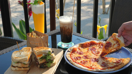 Al fresco dining scene with variety of popular foods including pizzaの写真素材
