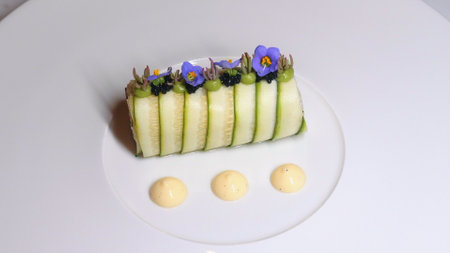 Elegant plating of gourmet cucumber appetizer garnished with edibleの写真素材