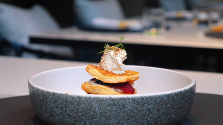 Gourmet dish with layered pancakes and garnish servedの写真素材