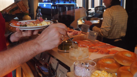 Hands serving variety of appetizers and snacks at buffet, showcasingの写真素材