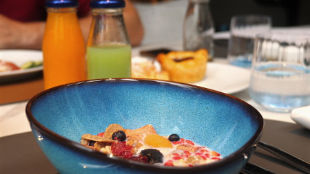 Close-up of nutritious breakfast with blue bowl of cereal topped withの写真素材
