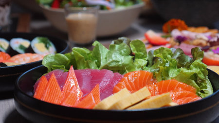 Colorful assortment of fresh sashimi and vegetable salads arranged onの写真素材