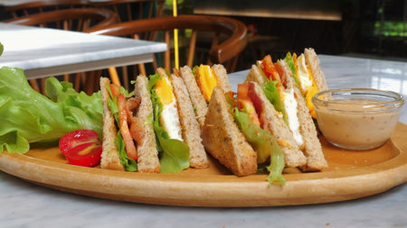 Delicious club sandwiches with lettuce, tomatoes, and side of dippingの写真素材