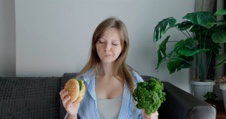 Woman contemplating burger vs healthy greens, nutrition dilemma,の写真素材