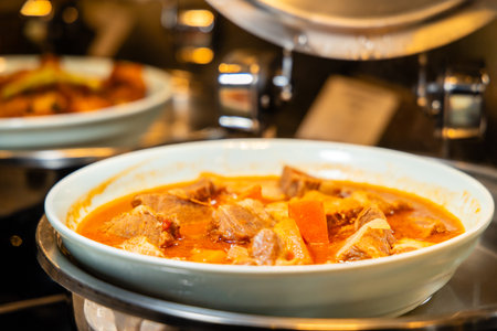 Hearty beef stew in white bowl, full of rich flavors, perfect for cozy