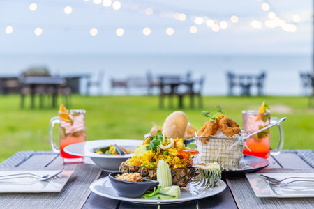 Outdoor dining table at beach restaurant with gourmet seafood dishes,の写真素材