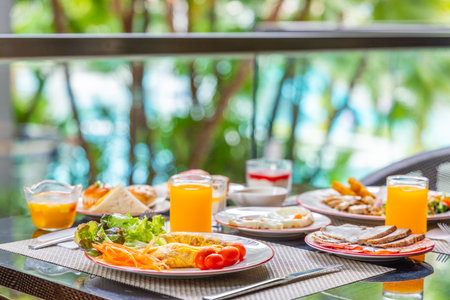Tropical outdoor breakfast setting with fresh omelet, orange juice,の写真素材