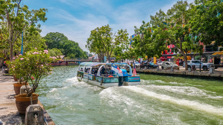 Tourists riding a river cruise boat along the Malacca River inのeditorial素材