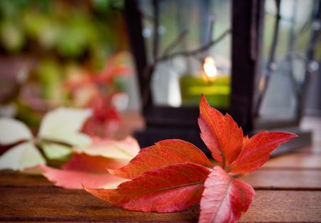 Lantern on the table with some autumn color leaves around