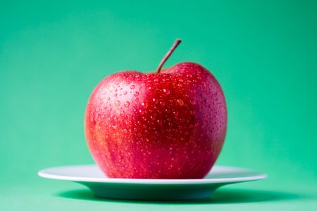 Red apple on green backgroundの写真素材