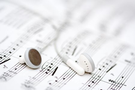 White earbuds on book of musical notesの写真素材