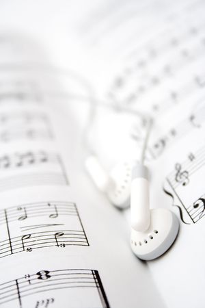 White earbuds on book of musical notesの写真素材