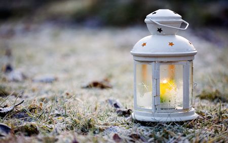 Decorative white lantern with burning candle insideの写真素材
