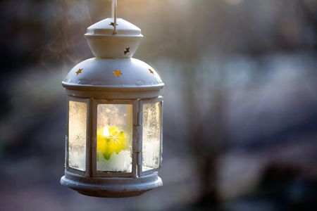 Decorative white lantern with burning candle insideの写真素材