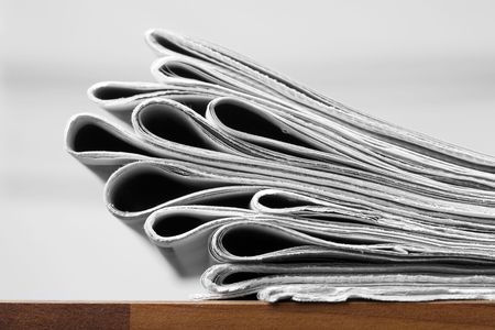 Folded newspapers on brown wooden table